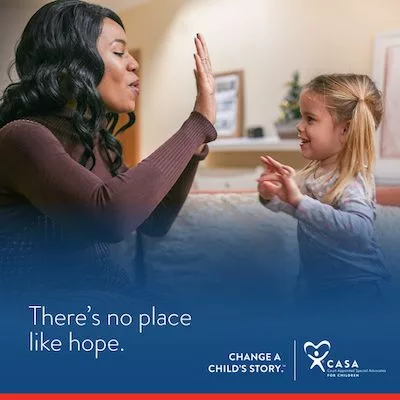 There's no place like hope - Change a child's story with CASA - A volunteer smiles and plays with a child in foster care